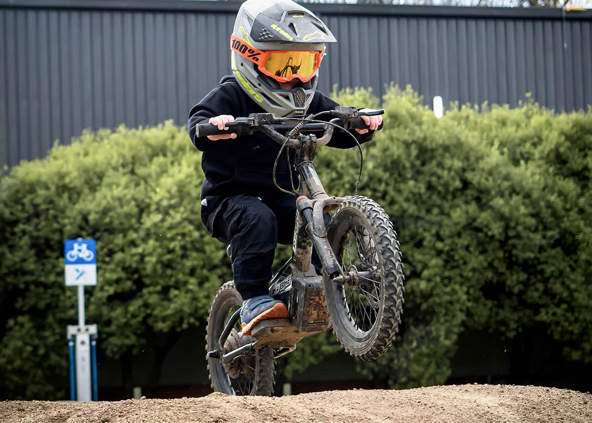 Young rider confidently manoeuvring the Gobike 16 on an off-road dirt course.