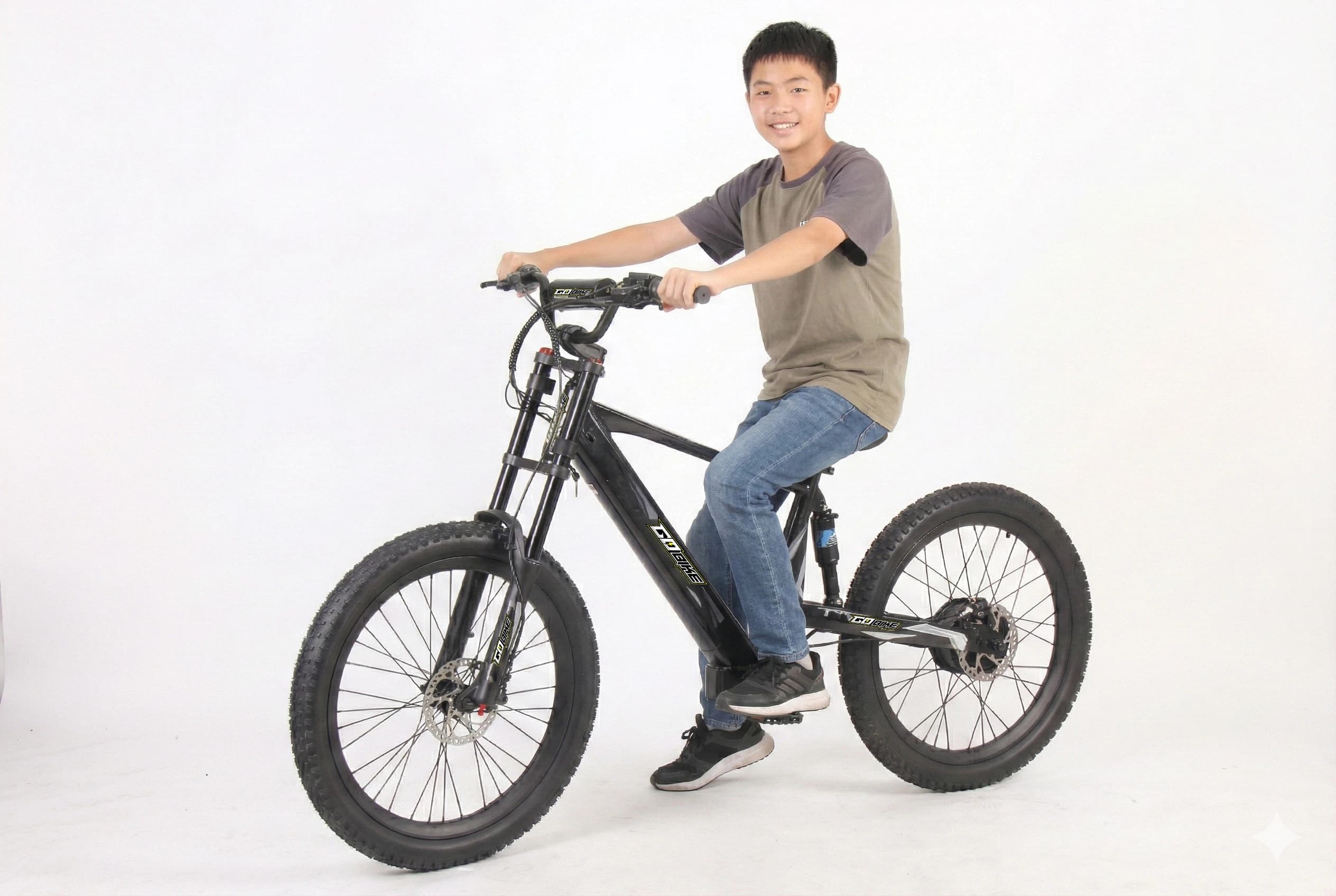 Teenager riding the GoBike 24 electric bike off-road.